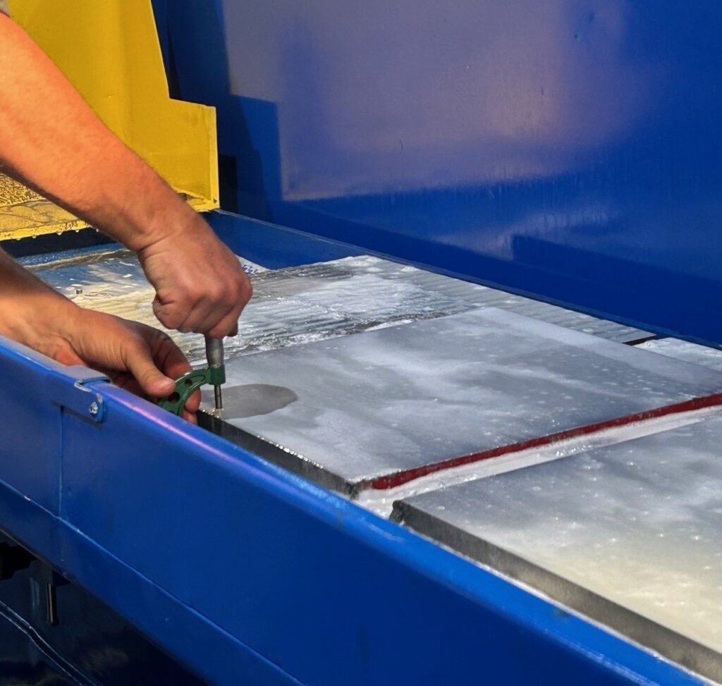 Hands making steel on a new machine